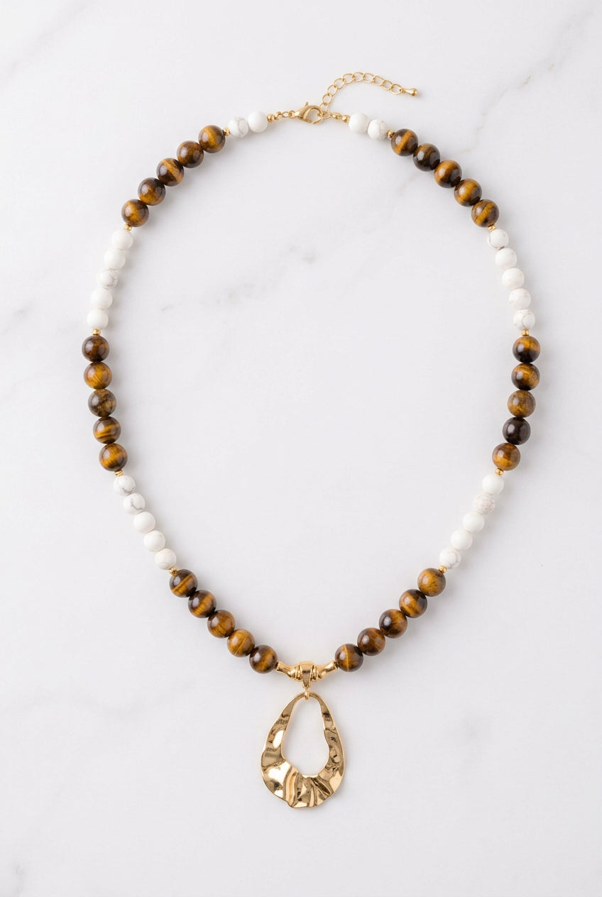 Colar Gota de Equilíbrio com contas claras de howlita, olho de tigre castanho e pendente dourado em forma de gota