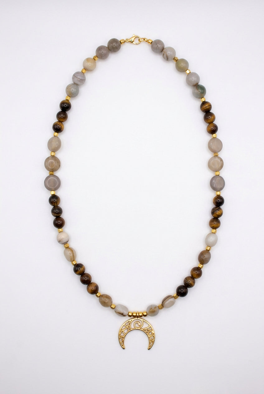 Colar Lua da Terra com contas em tons castanhos e claros e pendente de meia-lua dourado